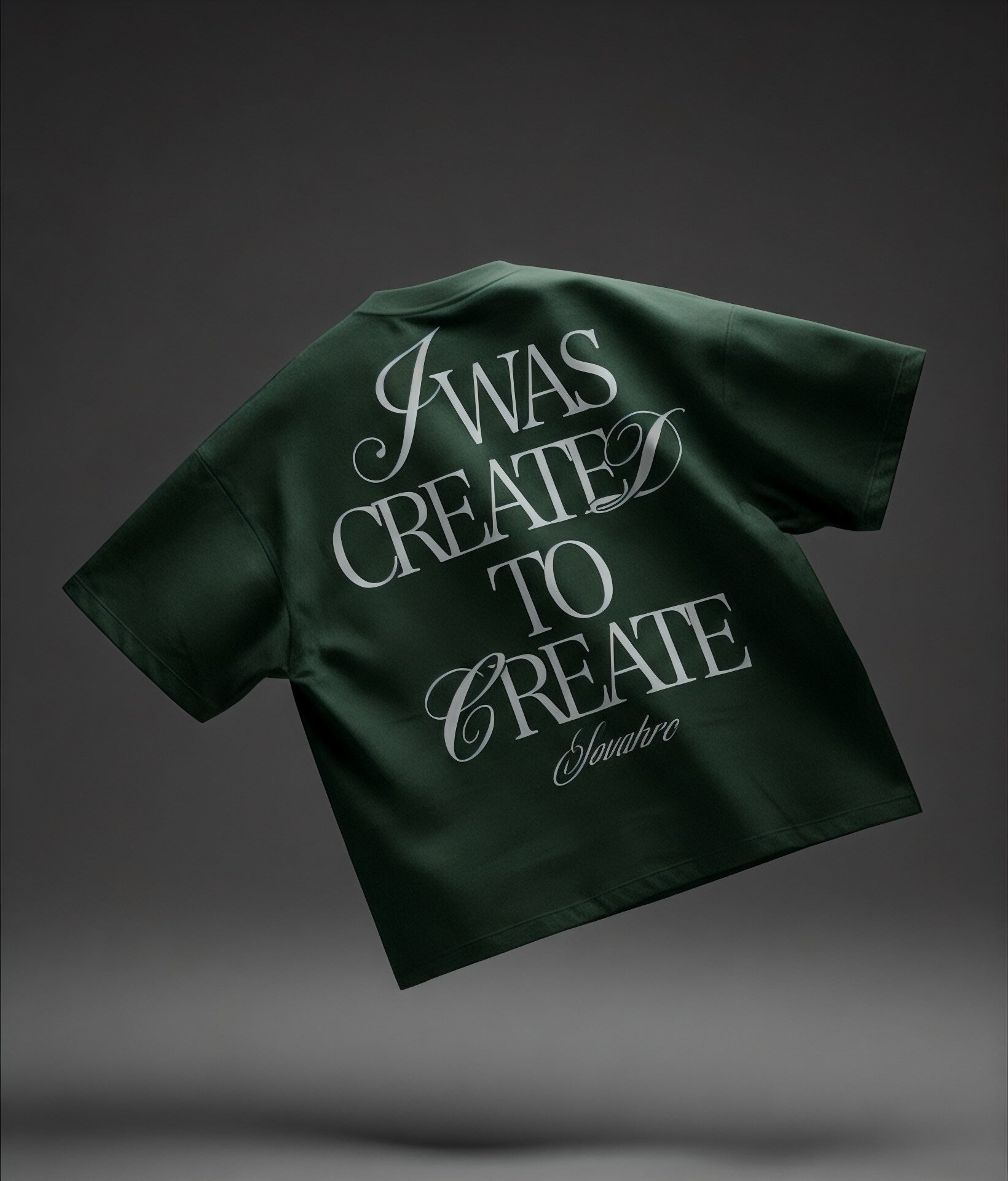 Green T-shirt with text 'I was created to create' on a dark gray background