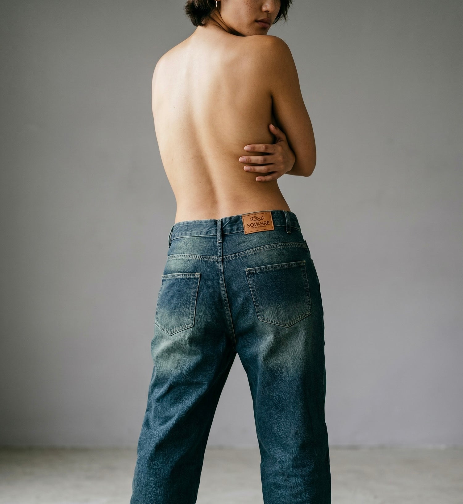 Person wearing blue jeans with a plain background