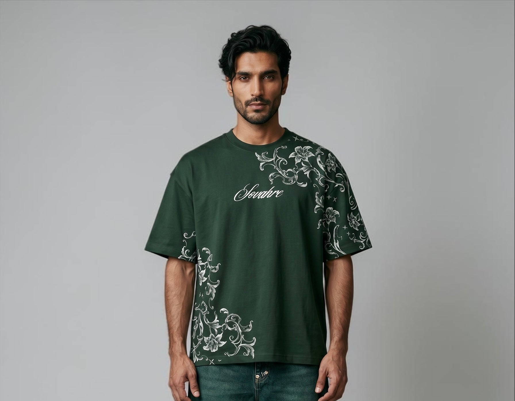 Man wearing a green t-shirt with white floral patterns and text on a gray background