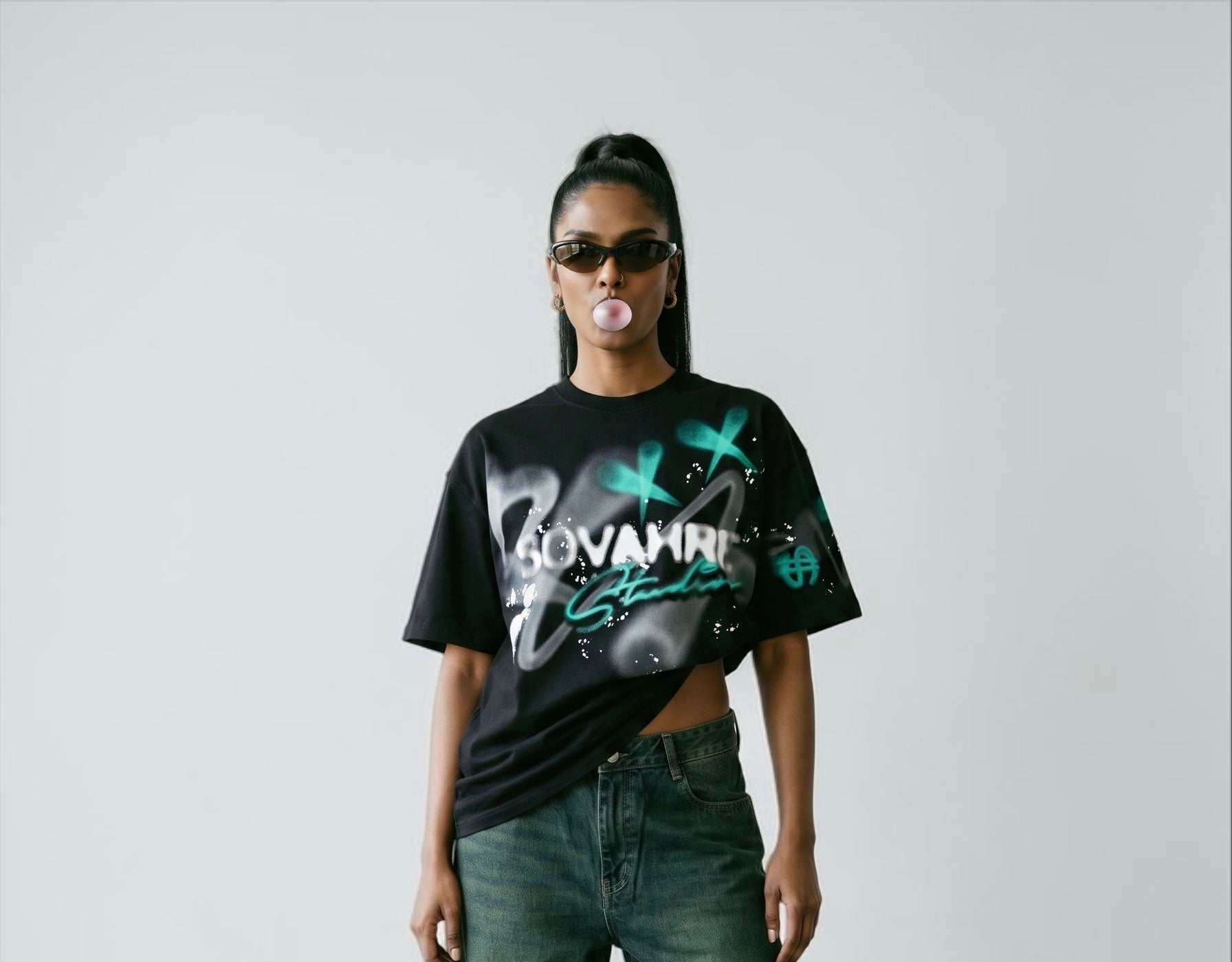 Person wearing a black t-shirt with graphic designs and text, standing against a plain background